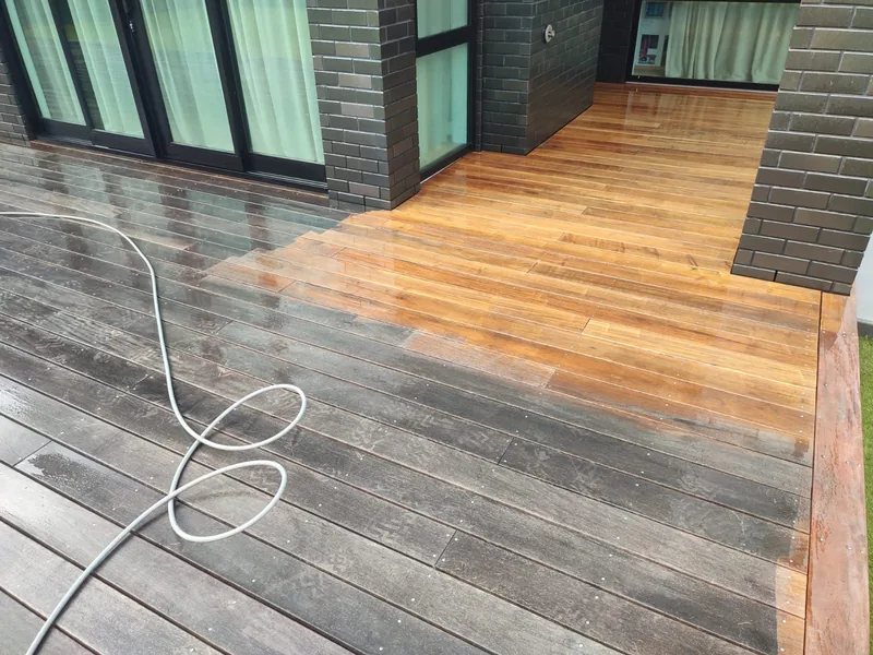 Timber deck showing a contrast between heavily weathered boards and a cleaned section