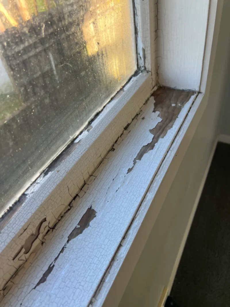 Old painted timber window frame with cracked and deteriorating coating